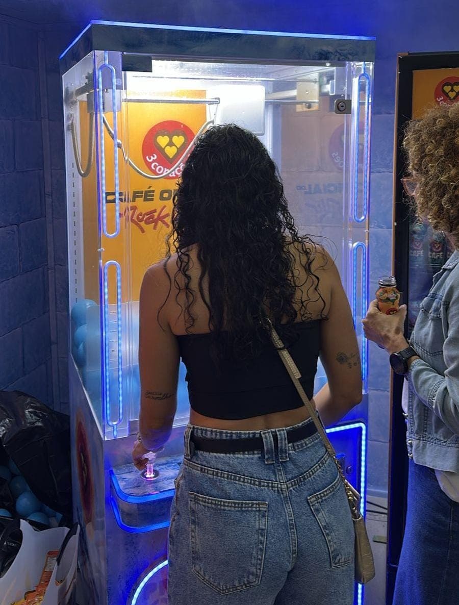 Ativação de marca em operação em estande de evento, com público interagindo com equipamento personalizado.